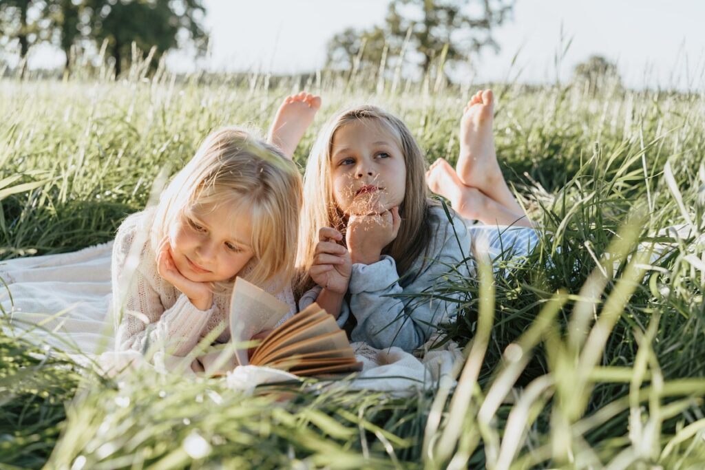 petites-filles-envie-de-lire-aux-enfants-dans-lherbe
